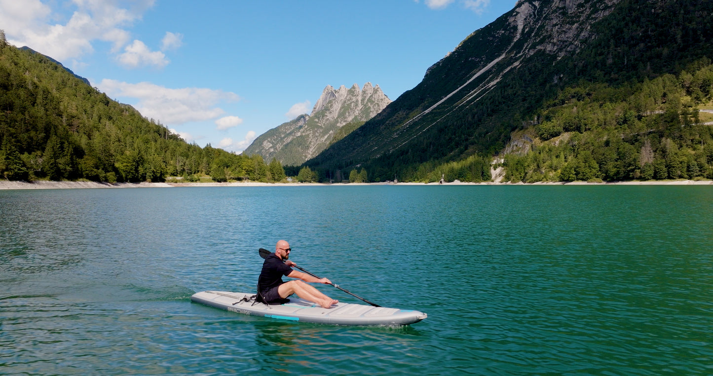 Rider on electric paddleboard with instructor on Montana lake in Glacier National Park – eSUP session booking at MontanaBoardingSchool.com. Rent from MTBoarders.com or buy from E-Boarders.com