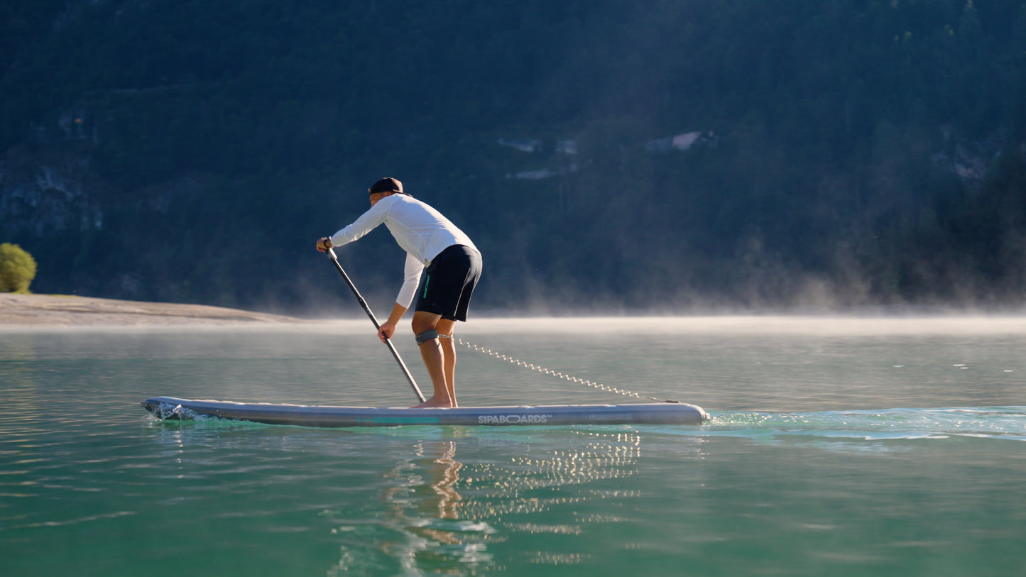 Rider on electric paddleboard with instructor on Montana lake in Glacier National Park – eSUP session booking at MontanaBoardingSchool.com. Rent from MTBoarders.com or buy from E-Boarders.com