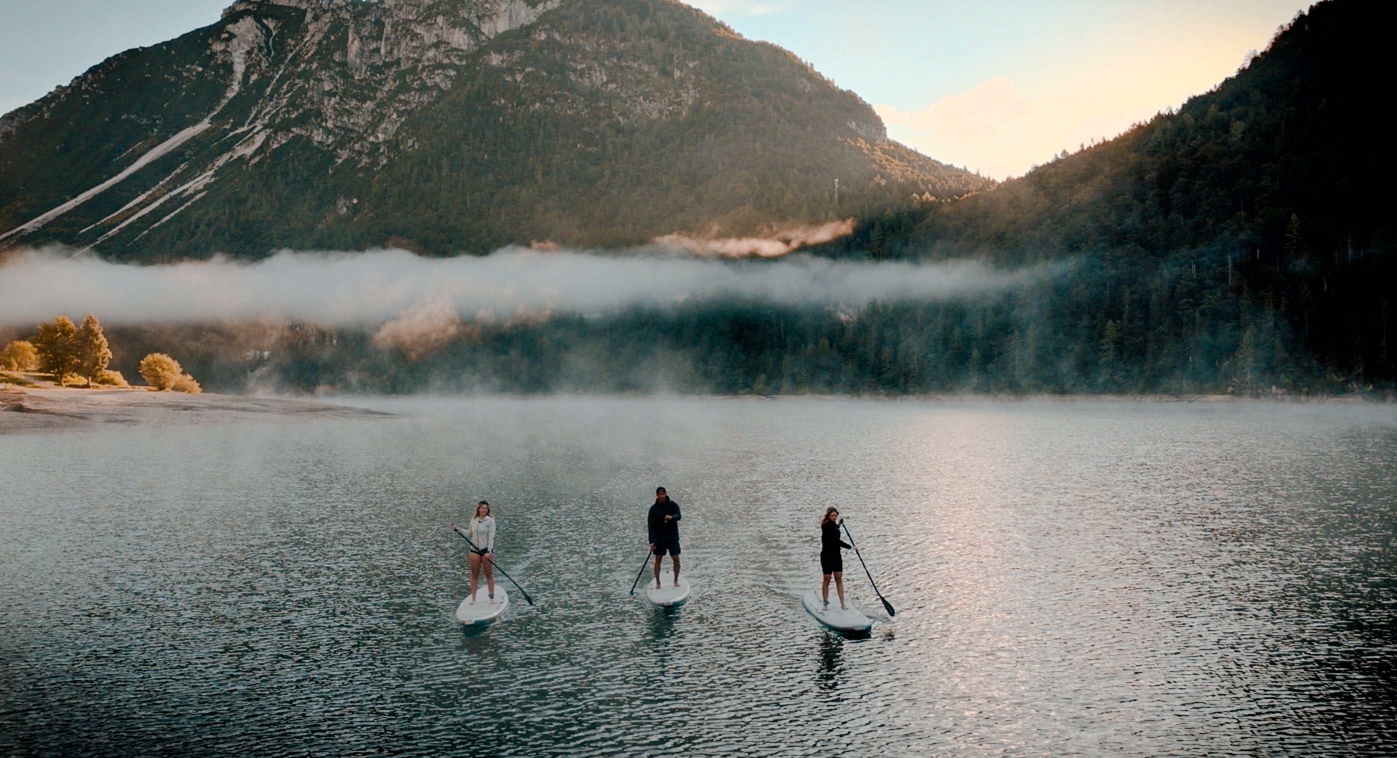 Rider on electric paddleboard with instructor on Montana lake in Glacier National Park – eSUP session booking at MontanaBoardingSchool.com. Rent from MTBoarders.com or buy from E-Boarders.com