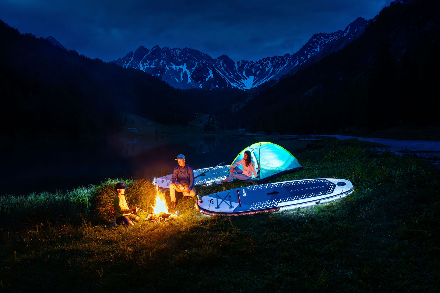 Group of paddleboarders glowing on the lake under moonlight during a night session – book a moonlight paddle party at MontanaBoardingSchool.com. Rent full daily and weekly rates at MTBoarders.com or buy now from eboarders.com
