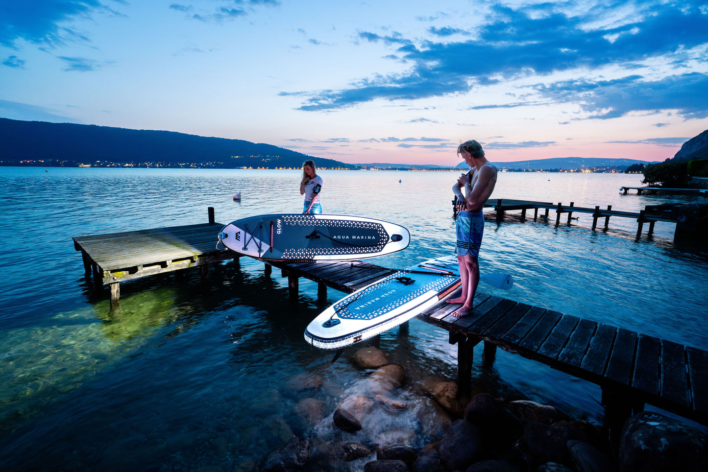 Group of paddleboarders glowing on the lake under moonlight during a night session – book a moonlight paddle party at MontanaBoardingSchool.com. Rent full daily and weekly rates at MTBoarders.com or buy now from eboarders.com