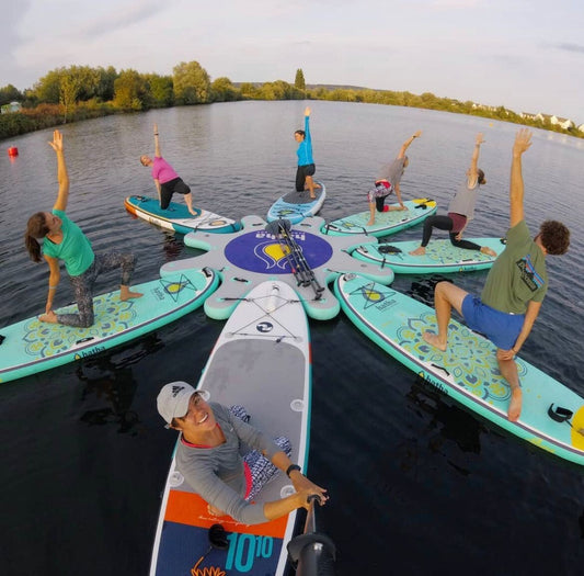Instructor leading floating yoga class on paddleboards in Montana – Book at MontanaBoardingSchool.com.