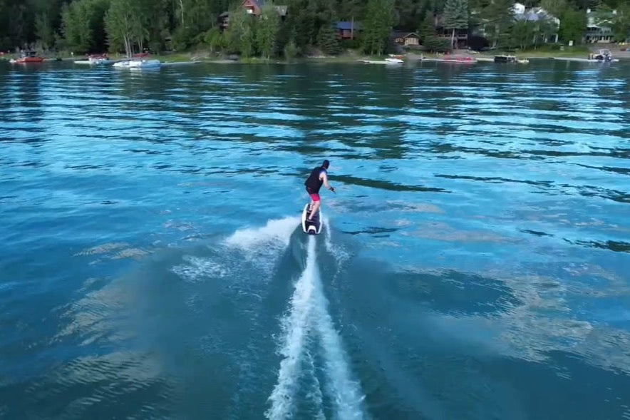 Person jetboarding on Flathead Lake with trees in the background